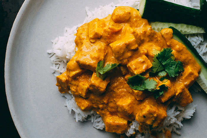 Creamy curry with tofu and cilantro over rice, reflecting a culinary preference praised by older generations.