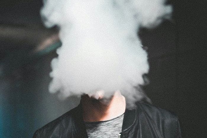 Person surrounded by smoke in dark setting, illustrating a common perspective shared by older generations.
