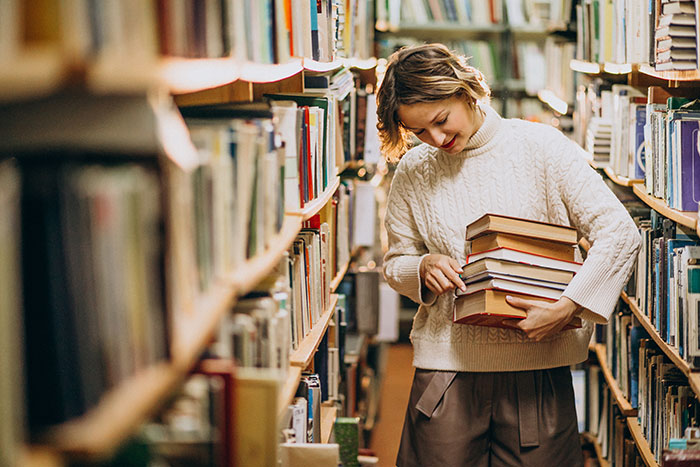 Person in a library holding books, reflecting on insights older generations got right.