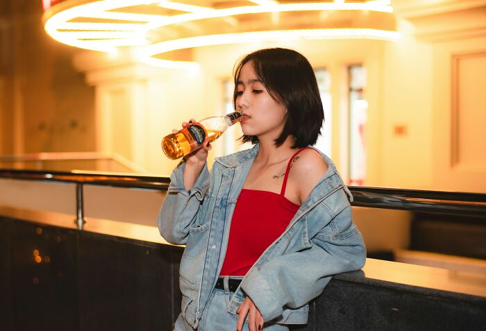 A person in casual attire sipping a drink, illustrating weirdest thing society accepts as normal.