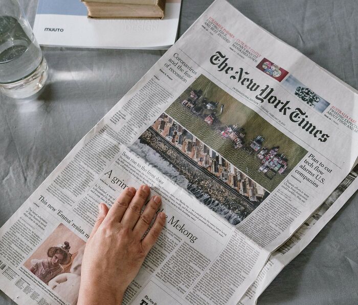 Hand on a New York Times newspaper, illustrating gradually disappeared things unnoticed by many.