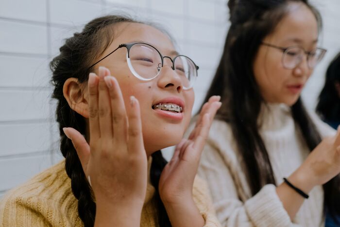Two people smiling, one with braids and glasses, highlighting internet users challenging stereotypes.
