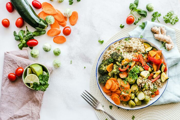 Healthy vegetable quinoa salad with carrots, broccoli, and zucchini on a table, surrounded by fresh ingredients. Healthy vegetable quinoa salad with carrots, broccoli, and zucchini on a table, surrounded by fresh ingredients.