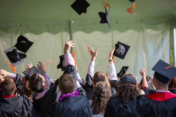 Students in graduation gowns and caps celebrating, symbolizing university courses achievement. Students in graduation gowns and caps celebrating, symbolizing university courses achievement.
