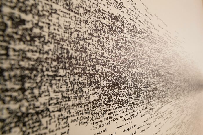 Text puzzle artwork illustrating the concept of 'odd one out' with dense, overlapping scribbles on a wall. Text puzzle artwork illustrating the concept of 'odd one out' with dense, overlapping scribbles on a wall.