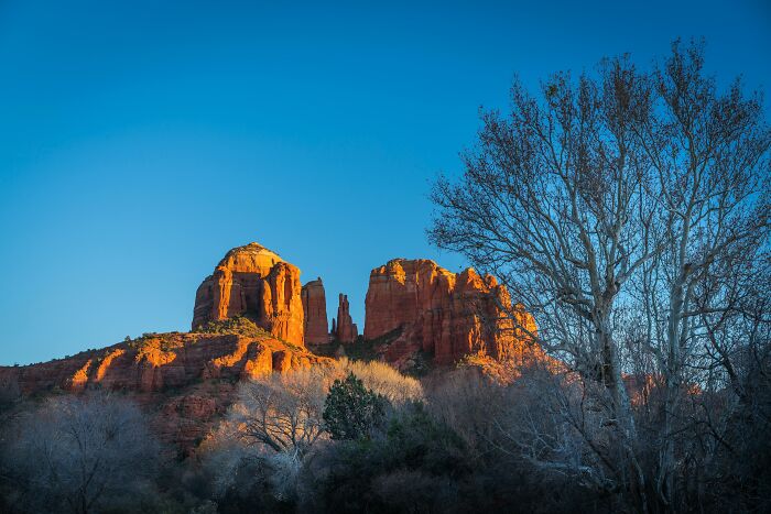 Red rock formations at sunset under a clear blue sky, evoking doubt about whether they're natural or man-made wonders. Red rock formations at sunset under a clear blue sky, evoking doubt about whether they're natural or man-made wonders.