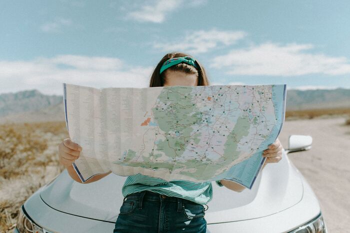 Person using a paper map for navigation, symbolizing gradually disappeared things.