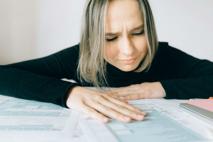 Woman concentrating on papers, appearing puzzled, related to language mastery and translation challenge. Woman concentrating on papers, appearing puzzled, related to language mastery and translation challenge.
