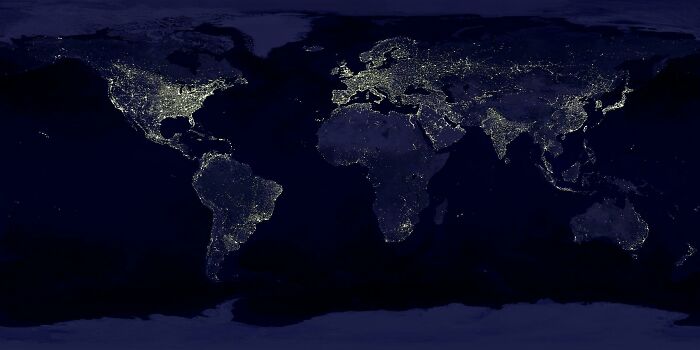 World map at night showing country borders highlighted by city lights. World map at night showing country borders highlighted by city lights.