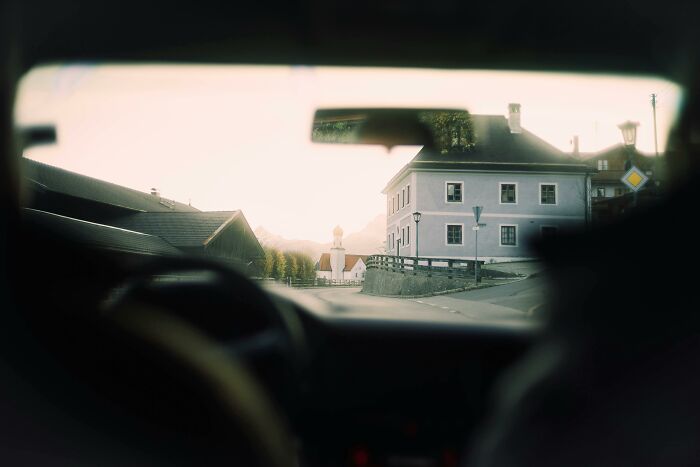 View from a car window in a small town at sunset, evoking feelings of being picked last in gym class.