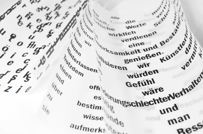 Curved papers displaying text in various languages, highlighting linguistic diversity. Curved papers displaying text in various languages, highlighting linguistic diversity.