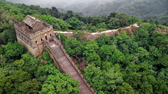 Aerial view of the Great Wall of China surrounded by lush greenery, illustrating common historical misconceptions.