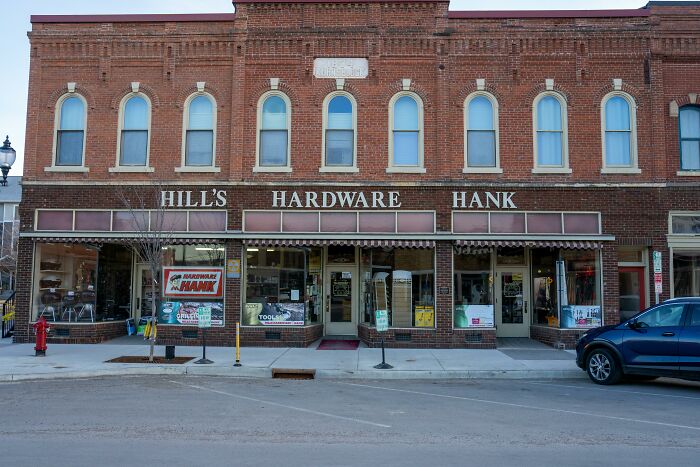 Historic brick hardware store facade, representing gradually disappeared community shops.