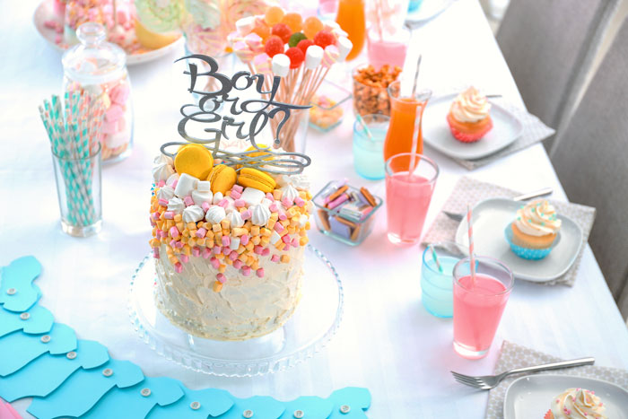 Gender reveal party setup with colorful cake and drinks. Gender reveal party setup with colorful cake and drinks.