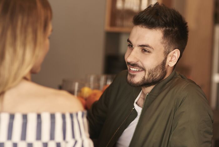 Man enjoying conversation at a cafe, representing how "pretty privilege" can benefit men too.