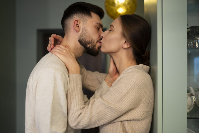 Couple embracing and sharing a kiss, illustrating pretty privilege in relationships.