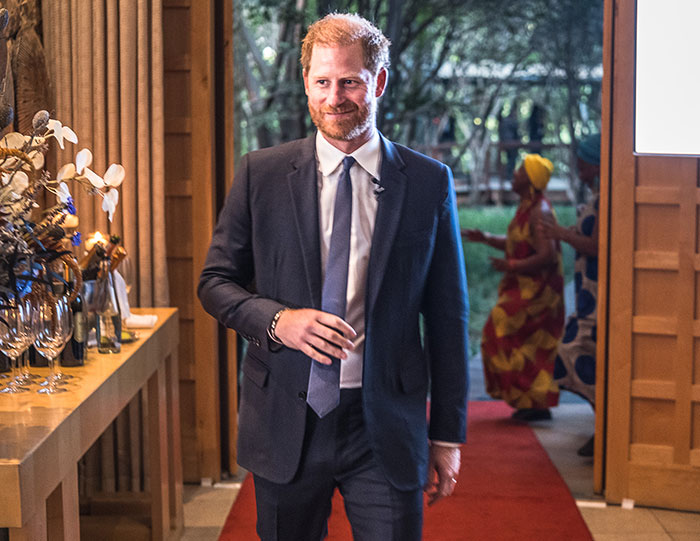Man in a suit walking on a red carpet, near a decorated table, outdoors. Man in a suit walking on a red carpet, near a decorated table, outdoors.