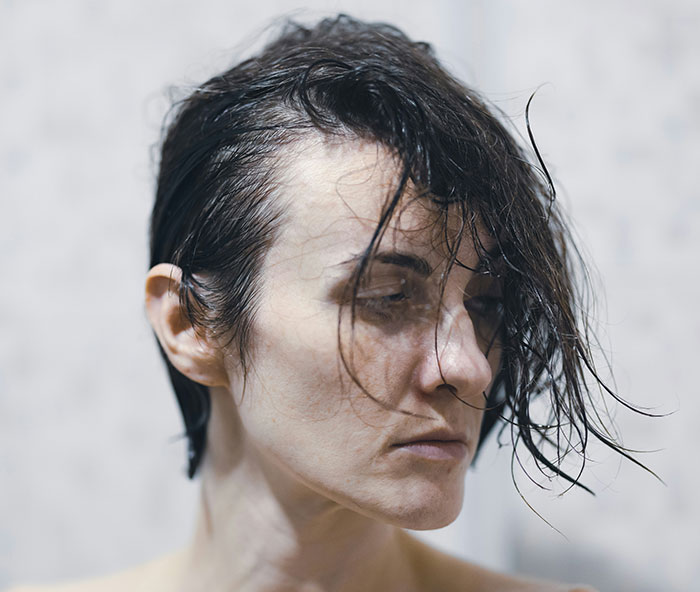 A woman with wet hair looks down, appearing contemplative or worried, relevant to a story about a horrible mother. A woman with wet hair looks down, appearing contemplative or worried, relevant to a story about a horrible mother.