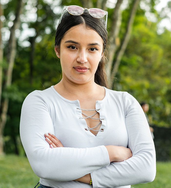 Woman outdoors with arms crossed, showcasing home ownership with a pool. Woman outdoors with arms crossed, showcasing home ownership with a pool.