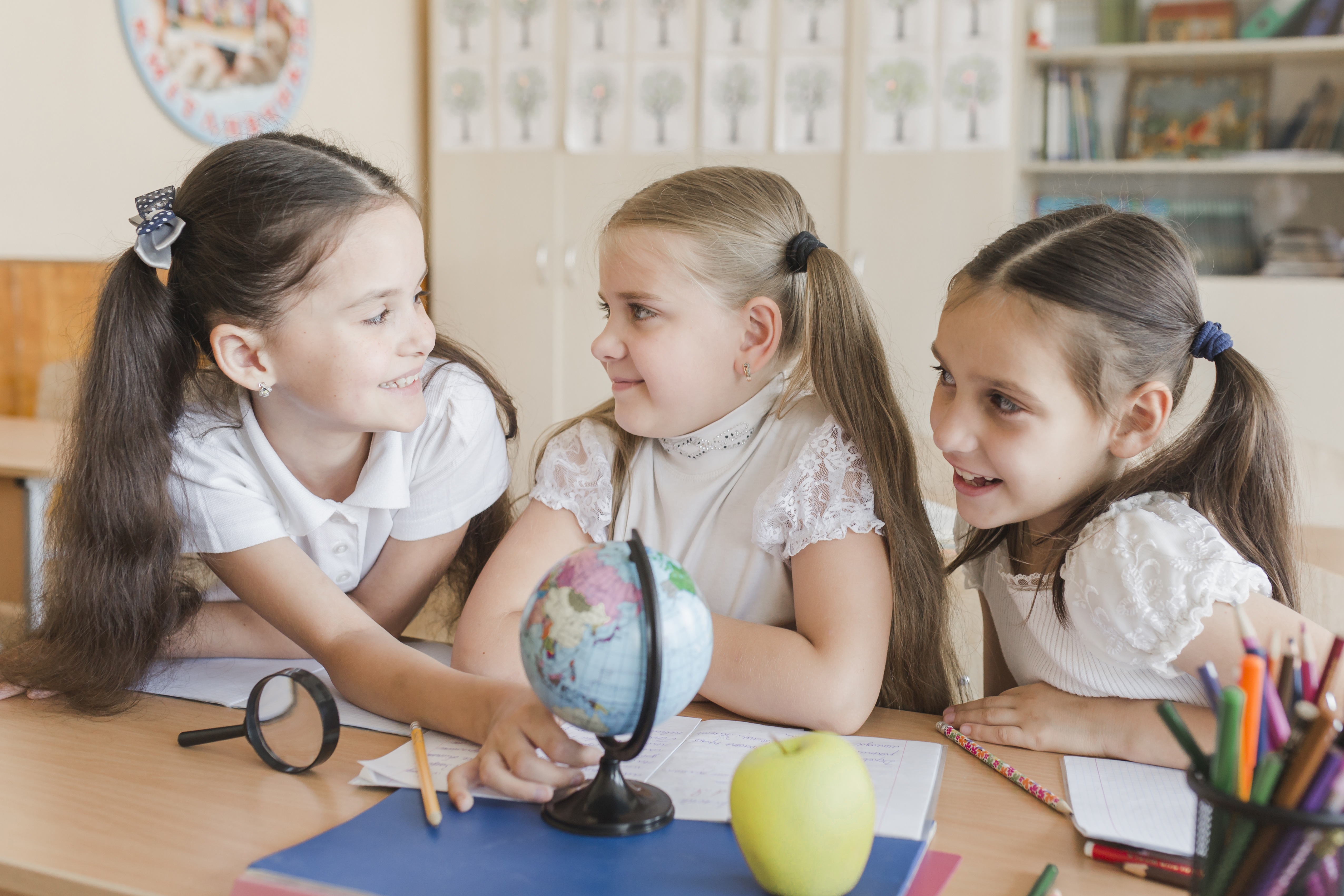Children engaged in classroom activities with a globe, promoting inclusion and friendship. Children engaged in classroom activities with a globe, promoting inclusion and friendship.