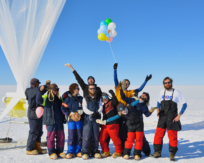 Team at Antarctic base celebrating with balloons in the snow, under blue skies. Team at Antarctic base celebrating with balloons in the snow, under blue skies.