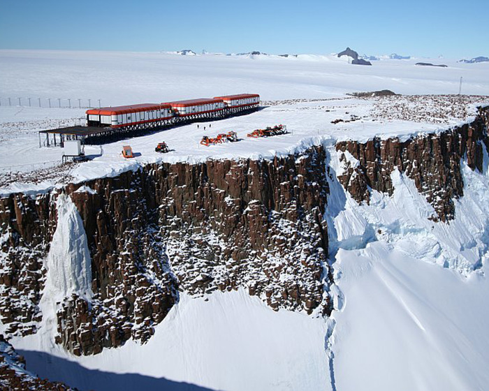 Antarctica research station atop a snowy cliff, highlighting remote isolation. Antarctica research station atop a snowy cliff, highlighting remote isolation.