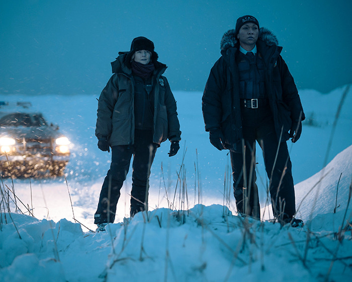 Scientists in Antarctica seeking help, standing in snow with coats and hats as car lights illuminate the scene. Scientists in Antarctica seeking help, standing in snow with coats and hats as car lights illuminate the scene.