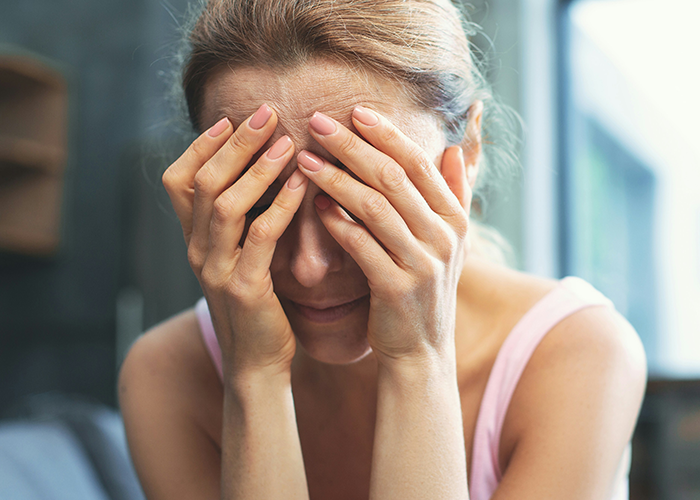 Woman covering face with hands, distressed about ex's criminal record. Woman covering face with hands, distressed about ex's criminal record.