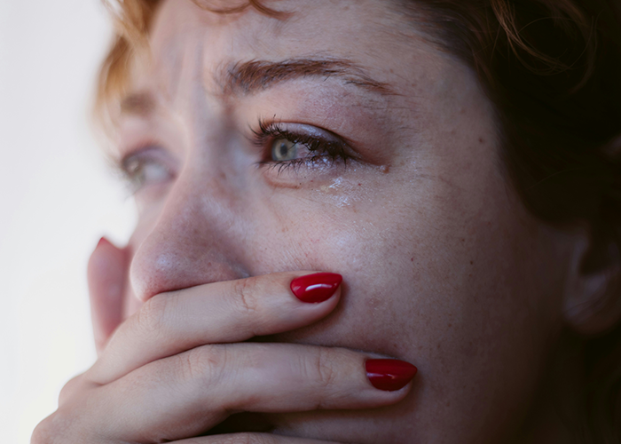 Upset woman with red nails, emotional reaction linked to ex's criminal record. Upset woman with red nails, emotional reaction linked to ex's criminal record.