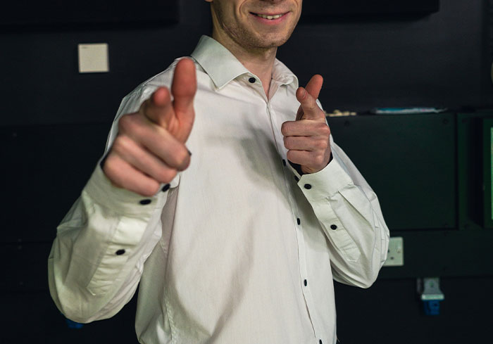 Man in white shirt pointing fingers, resembling a confident boss.