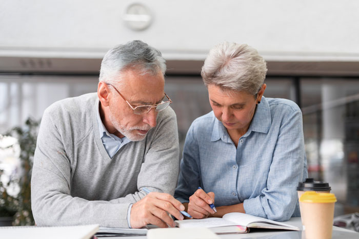 Older couple reviewing documents, highlighting family and inheritance discussions without children. Older couple reviewing documents, highlighting family and inheritance discussions without children.