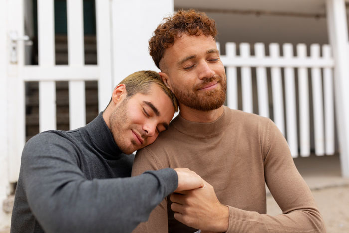 Two gay men embracing outdoors, showing comfort and support. Two gay men embracing outdoors, showing comfort and support.