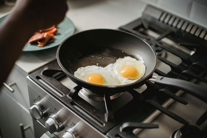 Eggs cooking in a skillet on a stove, illustrating the concept of a stolen skillet in use. Eggs cooking in a skillet on a stove, illustrating the concept of a stolen skillet in use.