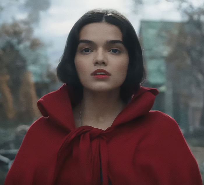 Young woman in a red cloak looks ahead, with soft lighting and blurred background. Snow White movie scene. Young woman in a red cloak looks ahead, with soft lighting and blurred background. Snow White movie scene.