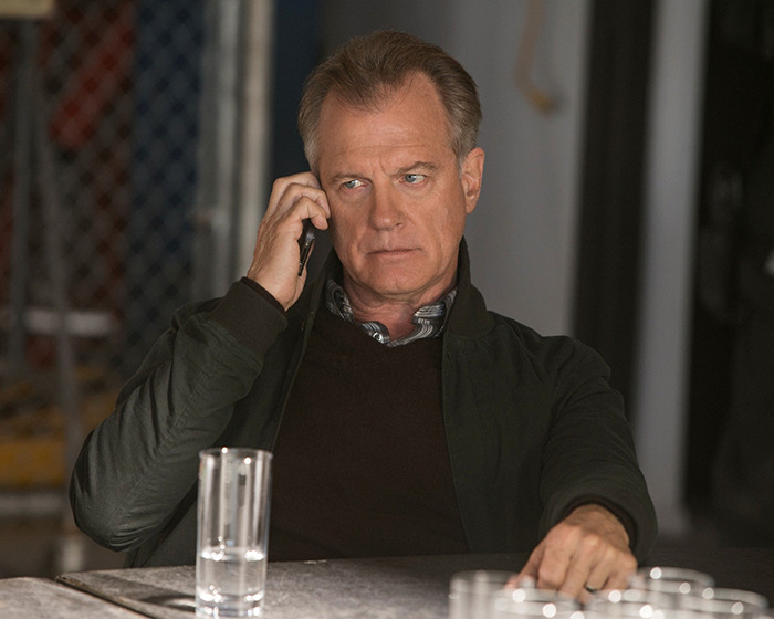 Disgraced actor on phone, seated at table, wearing a dark jacket and brown sweater. Disgraced actor on phone, seated at table, wearing a dark jacket and brown sweater.