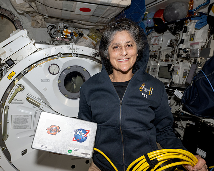 NASA astronaut holding equipment inside a spacecraft. NASA astronaut holding equipment inside a spacecraft.