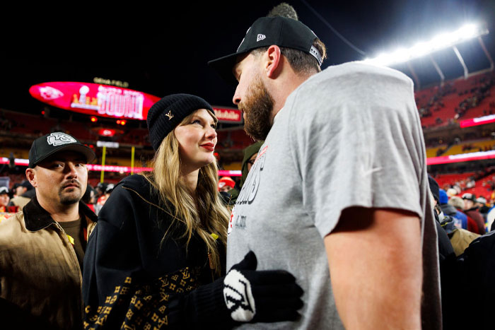 Taylor Swift and Travis Kelce interacting closely at a football game, generating buzz among fans.