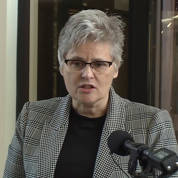 District Attorney Mary Moriarty in a plaid jacket speaking into a microphone. District Attorney Mary Moriarty in a plaid jacket speaking into a microphone.