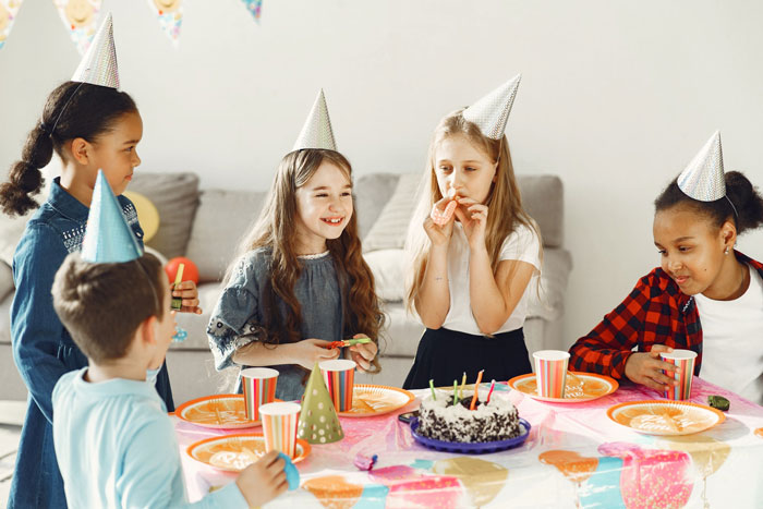 Children at birthday party wearing hats, eating cake. Children at birthday party wearing hats, eating cake.