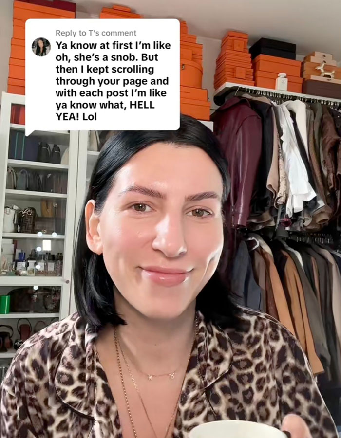 Person in a leopard print shirt holding a cup, smiling in front of a wardrobe. Child-free lifestyle discussion above. Person in a leopard print shirt holding a cup, smiling in front of a wardrobe. Child-free lifestyle discussion above.