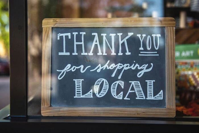 Chalkboard with "Thank You for Shopping Local" message, representing gradually disappeared local shopping habits.