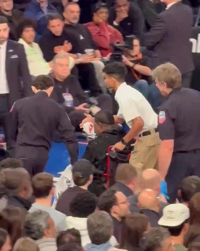 Steven Spielberg's daughter reacts in a crowded event scene, with people attending to someone sitting nearby. Steven Spielberg's daughter reacts in a crowded event scene, with people attending to someone sitting nearby.
