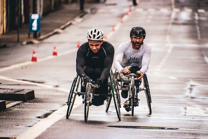Athletes in wheelchairs racing on a city street, showcasing unexpected things in reality.