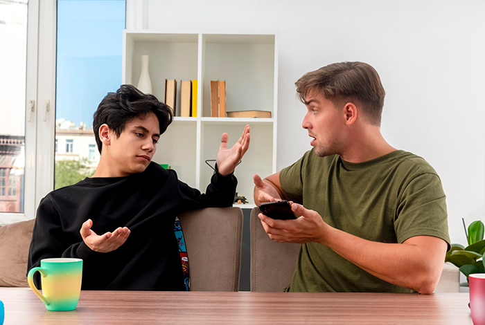 Two men having an animated discussion in a bright room, possibly about vacation reimbursement or a dog-related expense. Two men having an animated discussion in a bright room, possibly about vacation reimbursement or a dog-related expense.