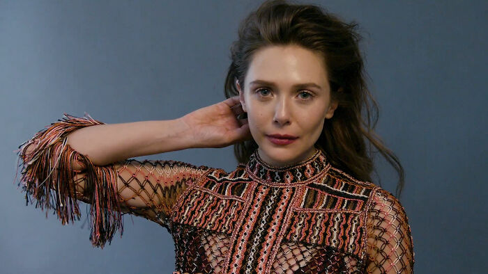 A celebrity posing confidently in a stylish, embroidered outfit, captivating netizens' attention.