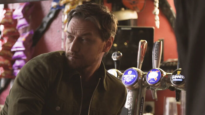 A person in a bar with beer taps, wearing a green jacket, capturing attention like celebrities do online.