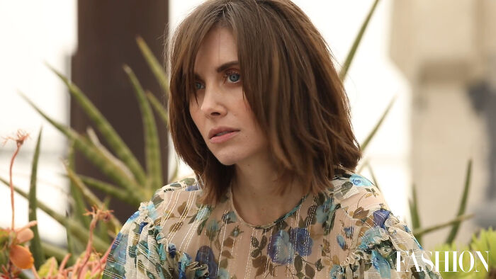 Woman in floral dress amidst plants, captivating netizens with her style.