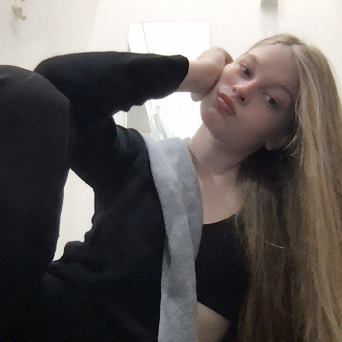 Young woman with long hair poses thoughtfully, wearing a black outfit. Young woman with long hair poses thoughtfully, wearing a black outfit.