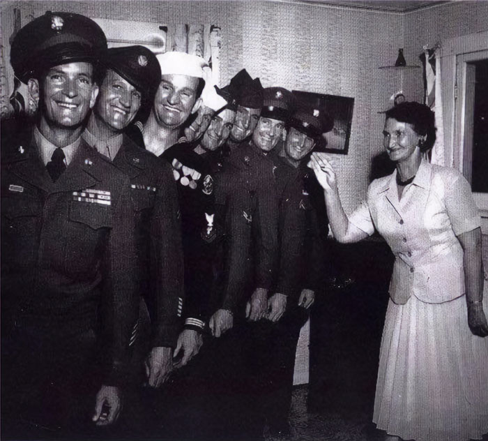 Smiling soldiers and a woman in vintage American home, showcasing everyday life of the past. Smiling soldiers and a woman in vintage American home, showcasing everyday life of the past.