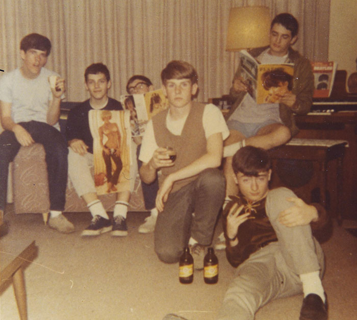 Vintage photo showing young men in casual attire, reading magazines and enjoying drinks, capturing past American life. Vintage photo showing young men in casual attire, reading magazines and enjoying drinks, capturing past American life.